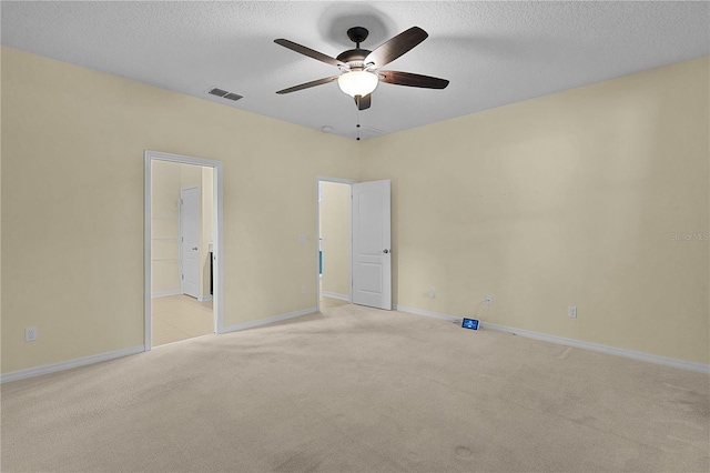 2424 Plumadore Dr, Grand Island, FL 32735 - unfurnished bedroom featuring light colored carpet, baseboards, a textured ceiling, a ceiling fan, and ensuite bath