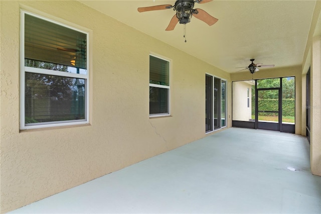 2424 Plumadore Dr, Grand Island, FL 32735 - unfurnished sunroom with ceiling fan, a textured wall, and concrete flooring