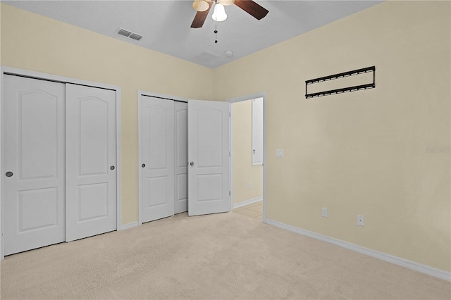 2424 Plumadore Dr, Grand Island, FL 32735 - unfurnished bedroom featuring two closets, light colored carpet, baseboards, and a ceiling fan