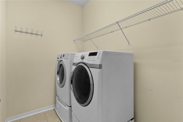 2424 Plumadore Dr, Grand Island, FL 32735 - washroom with washing machine and clothes dryer, light tile patterned flooring, and baseboards