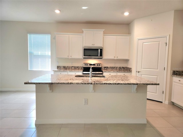 6203 SW 93rd Loop, Ocala, FL 34476 - kitchen featuring stainless steel appliances, a kitchen breakfast bar, a center island with sink, light stone countertops, and recessed lighting
