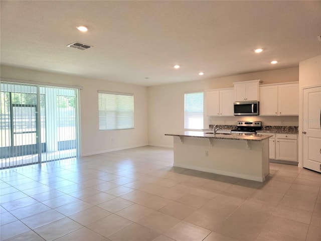 6203 SW 93rd Loop, Ocala, FL 34476 - kitchen featuring stainless steel appliances, plenty of natural light, light stone counters, recessed lighting, and a kitchen breakfast bar