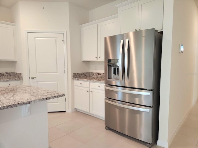 6203 SW 93rd Loop, Ocala, FL 34476 - kitchen featuring stainless steel fridge, white cabinets, light tile patterned floors, and light stone counters