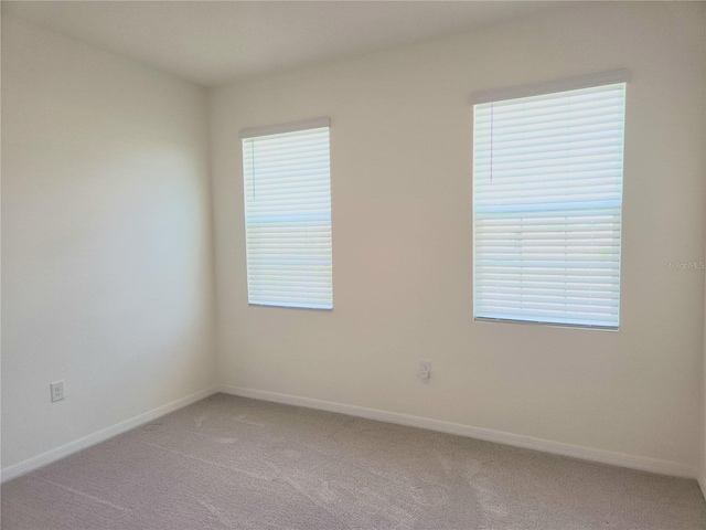 6203 SW 93rd Loop, Ocala, FL 34476 - empty room with light colored carpet, baseboards, and plenty of natural light