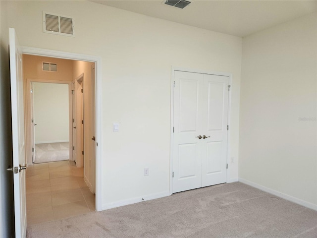 6203 SW 93rd Loop, Ocala, FL 34476 - unfurnished bedroom with light carpet, baseboards, a closet, and light tile patterned floors