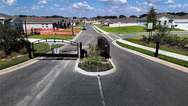 6203 SW 93rd Loop, Ocala, FL 34476 - view of asphalt road featuring a residential view, curbs, sidewalks, a gate, and a gated entry