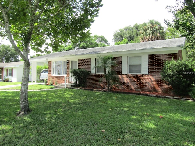2501 Sheridan Rd, Mount Dora, FL 32757 - ranch-style house with brick siding, a front yard, and an attached carport