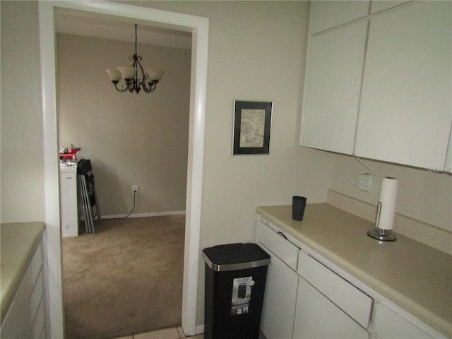 2501 Sheridan Rd, Mount Dora, FL 32757 - kitchen with light colored carpet, light countertops, white cabinetry, a chandelier, and baseboards