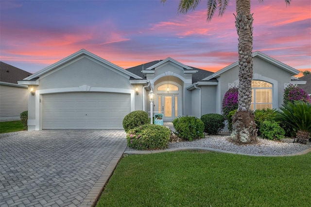 1521 Southport St, The Villages, FL 32162 - ranch-style house with stucco siding, a garage, decorative driveway, and a front lawn