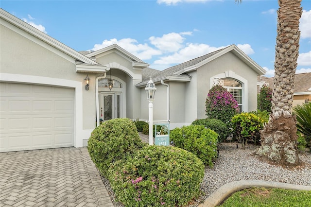1521 Southport St, The Villages, FL 32162 - view of front of house featuring stucco siding, an attached garage, and decorative driveway