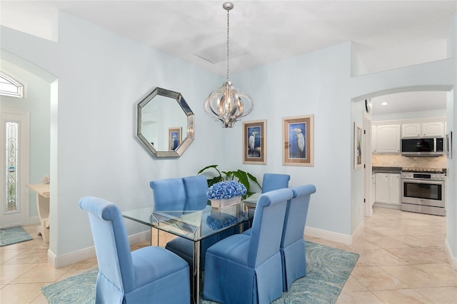 1521 Southport St, The Villages, FL 32162 - dining space featuring arched walkways, a chandelier, light tile patterned flooring, and baseboards