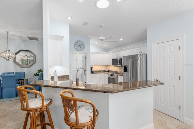 1521 Southport St, The Villages, FL 32162 - kitchen with appliances with stainless steel finishes, vaulted ceiling, a peninsula, white cabinetry, and ceiling fan