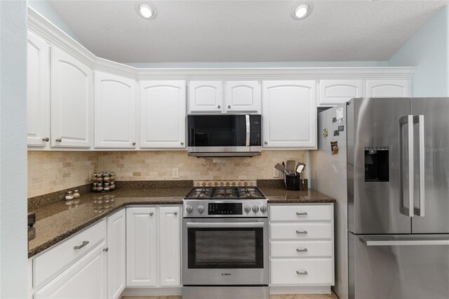 1521 Southport St, The Villages, FL 32162 - kitchen featuring stainless steel appliances, white cabinetry, dark stone counters, and tasteful backsplash
