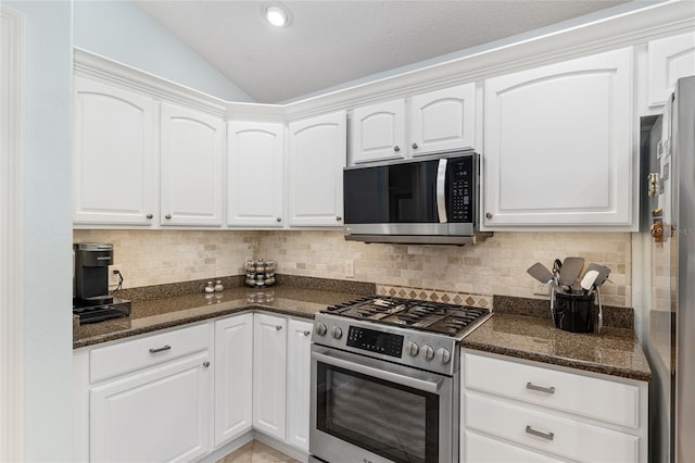 1521 Southport St, The Villages, FL 32162 - kitchen with stainless steel appliances, lofted ceiling, white cabinets, tasteful backsplash, and dark stone counters