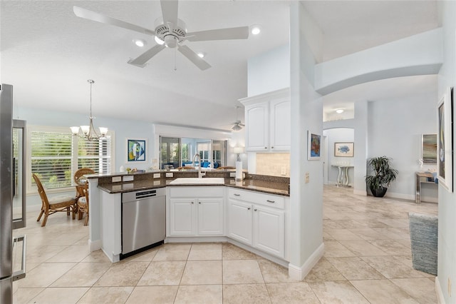 1521 Southport St, The Villages, FL 32162 - kitchen with stainless steel appliances, a sink, a ceiling fan, arched walkways, and a peninsula