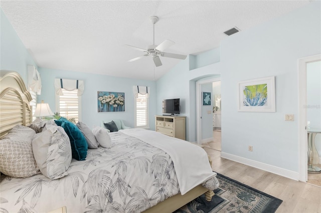 1521 Southport St, The Villages, FL 32162 - bedroom with vaulted ceiling, a textured ceiling, light wood-type flooring, arched walkways, and baseboards