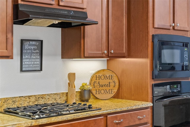 26822 Bull Run, Leesburg, FL 34748 - kitchen with under cabinet range hood, black appliances, light stone counters, and brown cabinets