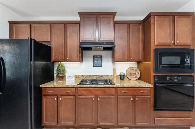26822 Bull Run, Leesburg, FL 34748 - kitchen featuring black appliances, under cabinet range hood, light stone countertops, and brown cabinets