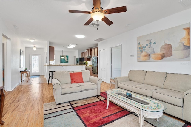 26822 Bull Run, Leesburg, FL 34748 - living room with light wood-style floors, ceiling fan, and baseboards