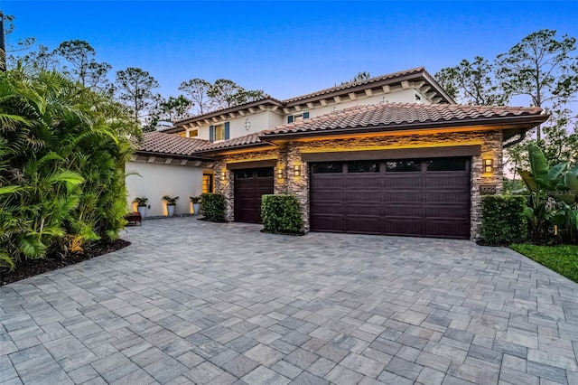 10122 Royal Island Ct, Orlando, FL 32836 - mediterranean / spanish home with an attached garage, decorative driveway, stone siding, and stucco siding