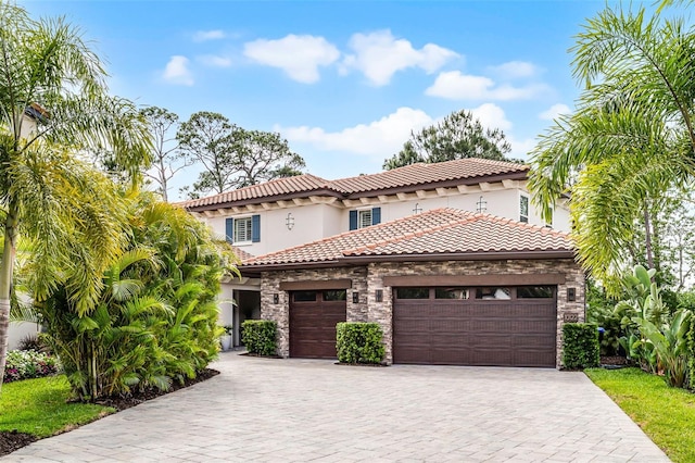 10122 Royal Island Ct, Orlando, FL 32836 - mediterranean / spanish-style house featuring an attached garage, stucco siding, stone siding, a tile roof, and driveway