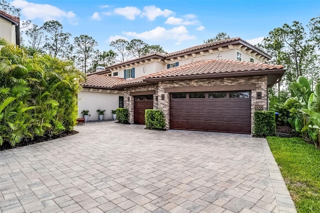 10122 Royal Island Ct, Orlando, FL 32836 - mediterranean / spanish-style house featuring stone siding, a garage, decorative driveway, and stucco siding