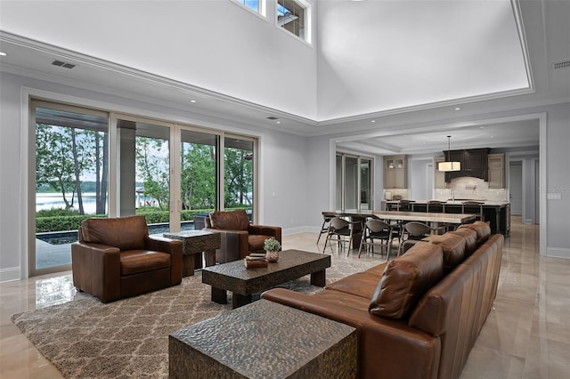 10122 Royal Island Ct, Orlando, FL 32836 - living room featuring crown molding, baseboards, a high ceiling, recessed lighting, and light marble finish flooring