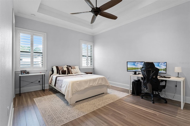 10122 Royal Island Ct, Orlando, FL 32836 - bedroom with ornamental molding, a tray ceiling, wood finished floors, baseboards, and ceiling fan
