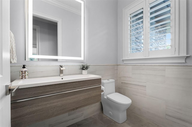 10122 Royal Island Ct, Orlando, FL 32836 - bathroom featuring toilet, tile walls, crown molding, vanity, and a wainscoted wall
