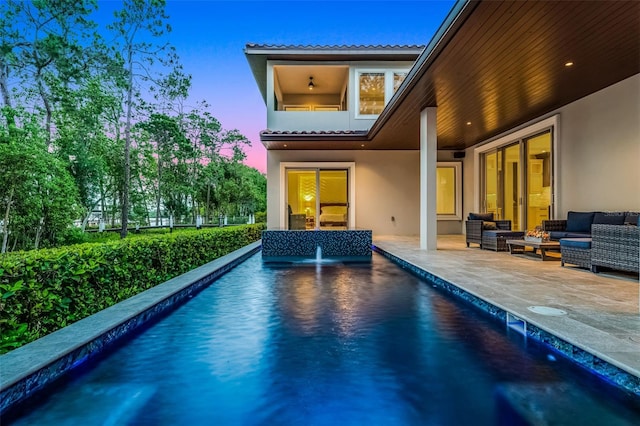 10122 Royal Island Ct, Orlando, FL 32836 - back of property featuring stucco siding, an outdoor living space, a patio area, an outdoor pool, and a tiled roof