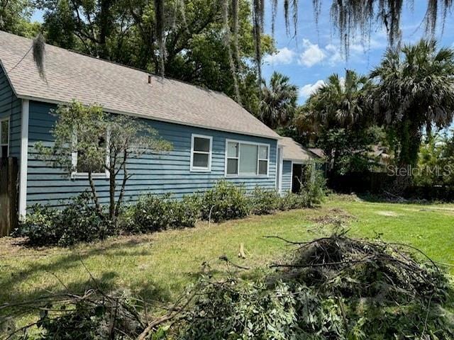 1225 E 1st Ave, Mount Dora, FL 32757 - view of side of home with a lawn and roof with shingles