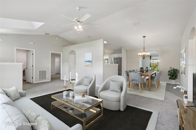 508 Woodview Dr, Tavares, FL 32778 - carpeted living area featuring vaulted ceiling, arched walkways, a ceiling fan, a chandelier, and baseboards
