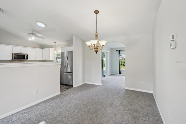 508 Woodview Dr, Tavares, FL 32778 - kitchen featuring stainless steel appliances, a chandelier, dark carpet, white cabinetry, and baseboards