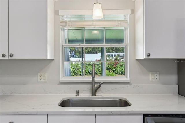 508 Woodview Dr, Tavares, FL 32778 - kitchen with a sink, dishwasher, white cabinetry, and hanging light fixtures
