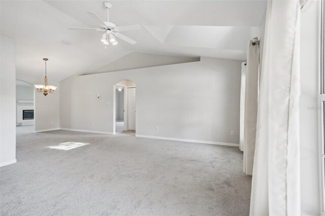 508 Woodview Dr, Tavares, FL 32778 - unfurnished living room with vaulted ceiling, carpet flooring, ceiling fan, arched walkways, and baseboards