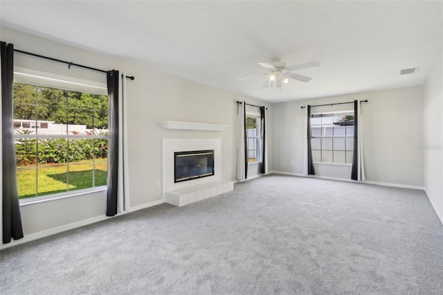 508 Woodview Dr, Tavares, FL 32778 - unfurnished living room featuring a ceiling fan, carpet flooring, a tiled fireplace, and baseboards