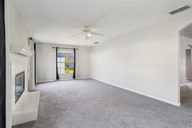508 Woodview Dr, Tavares, FL 32778 - unfurnished living room featuring arched walkways, a ceiling fan, carpet floors, and a glass covered fireplace