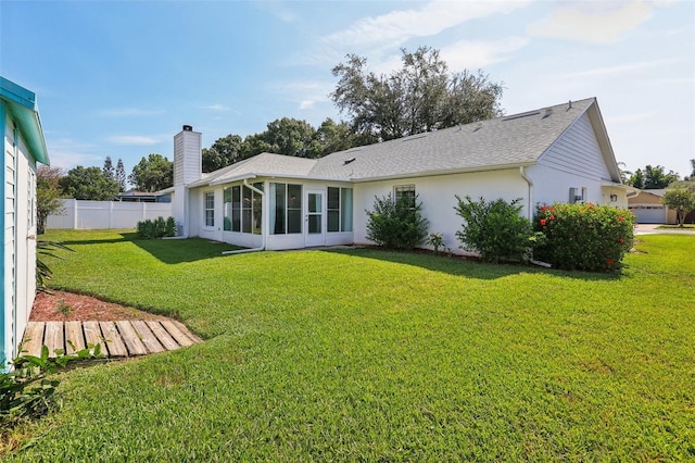 508 Woodview Dr, Tavares, FL 32778 - back of property with a chimney, a sunroom, stucco siding, and roof with shingles
