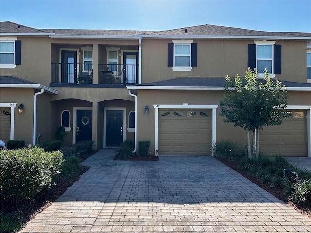 147 Aston Grande Dr, Daytona Beach, FL 32124 - view of property with a balcony, an attached garage, stucco siding, and decorative driveway