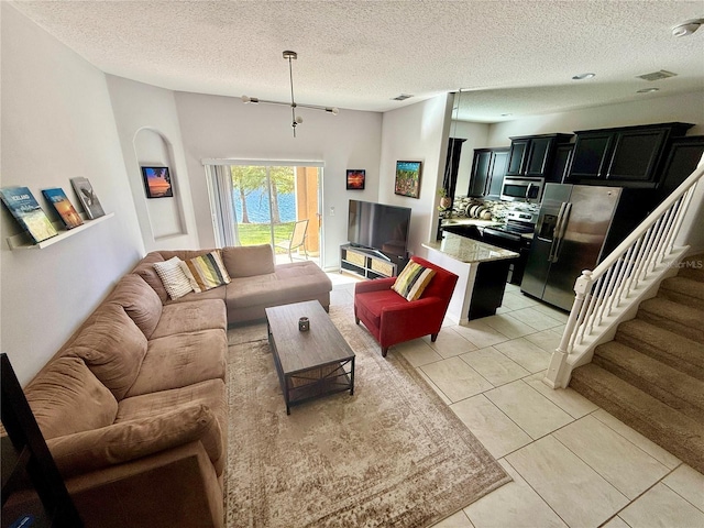 147 Aston Grande Dr, Daytona Beach, FL 32124 - living room with a textured ceiling, light tile patterned floors, and stairs