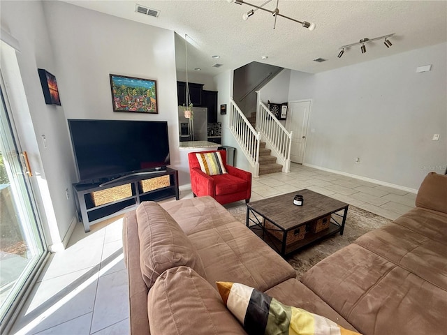 147 Aston Grande Dr, Daytona Beach, FL 32124 - living room featuring light tile patterned floors, stairway, a textured ceiling, and baseboards