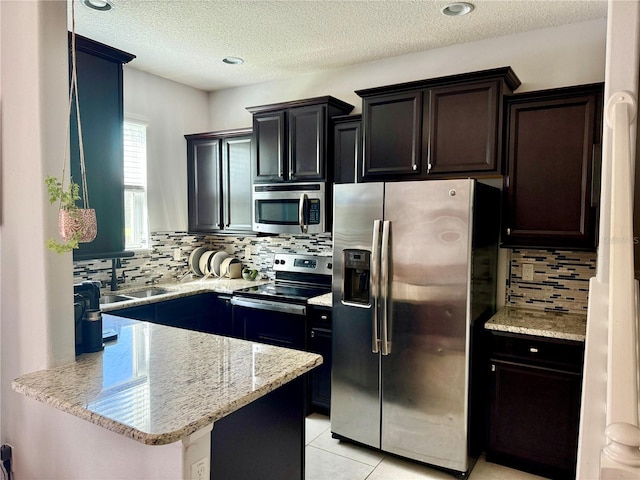 147 Aston Grande Dr, Daytona Beach, FL 32124 - kitchen with stainless steel appliances, light stone countertops, a textured ceiling, backsplash, and a peninsula