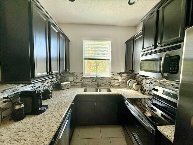 147 Aston Grande Dr, Daytona Beach, FL 32124 - kitchen with appliances with stainless steel finishes, a sink, tasteful backsplash, a textured ceiling, and light tile patterned floors