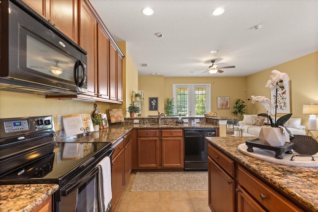 2064 Rafton Rd, Apopka, FL 32703 - kitchen with black appliances, open floor plan, brown cabinets, a ceiling fan, and dark stone counters