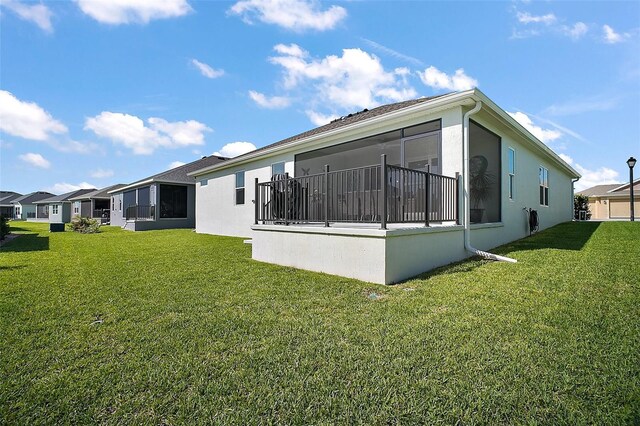 1627 Mclucas Ln, The Villages, FL 34762 - rear view of property featuring stucco siding, a yard, and a sunroom