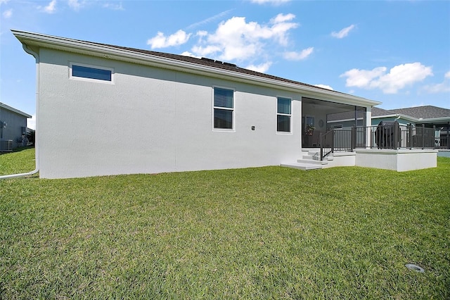 1627 Mclucas Ln, The Villages, FL 34762 - rear view of house with a yard, central air condition unit, stucco siding, and a sunroom