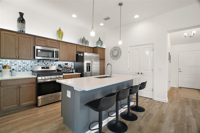 1627 Mclucas Ln, The Villages, FL 34762 - kitchen with appliances with stainless steel finishes, a sink, tasteful backsplash, light wood-type flooring, and a kitchen breakfast bar