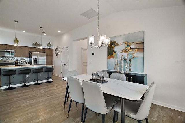 1627 Mclucas Ln, The Villages, FL 34762 - dining area with a chandelier, light wood-style flooring, recessed lighting, baseboards, and lofted ceiling