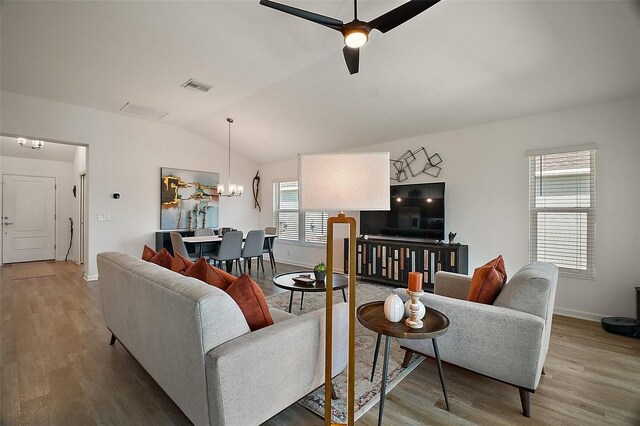 1627 Mclucas Ln, The Villages, FL 34762 - living area with wood finished floors, vaulted ceiling, baseboards, a ceiling fan, and a chandelier