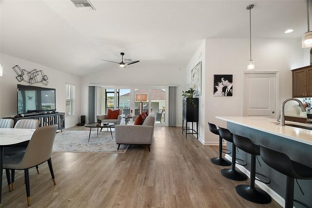 1627 Mclucas Ln, The Villages, FL 34762 - living area with light wood-type flooring, ceiling fan, baseboards, and vaulted ceiling